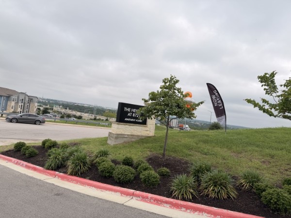Exterior property entrance monument sign and feather flag for The Heights at 8721, installed by E&A Signs