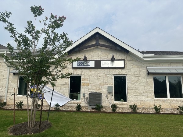 Exterior stone building with a mounted wall sign, installed by E&A Signs