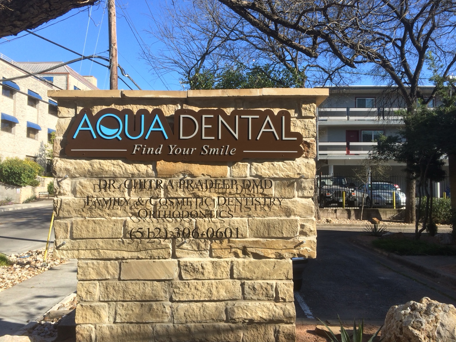Exterior stone monument sign reading Aqua Dental, installed by E&A Signs