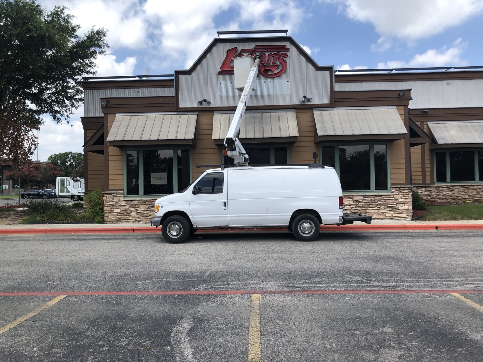 E&A Signs bucket van on site for an exterior storefront sign install