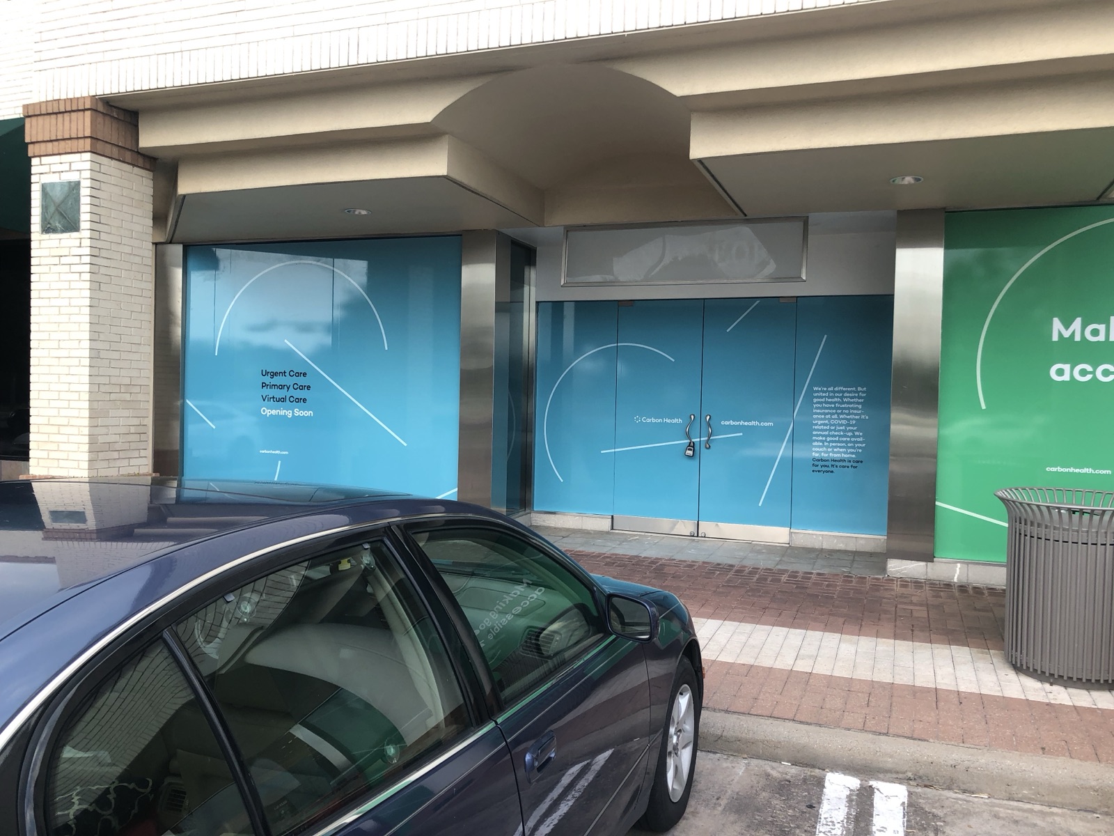 Exterior storefront entrance with window and door graphics, installed by E&A Signs