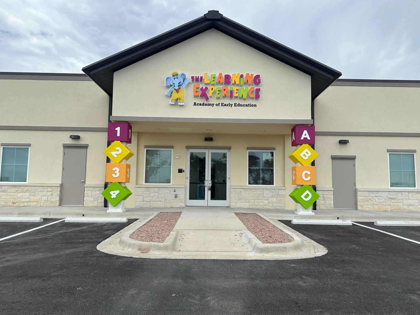 Exterior building sign and entrance banners for The Learning Experience, installed by E&A Signs